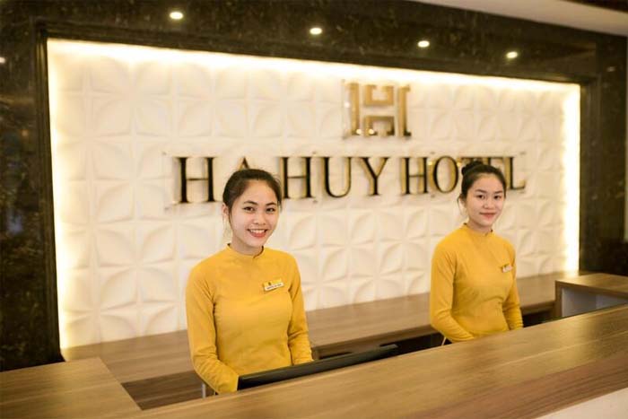 Lễ tân khách sạn trong trang phục áo dài sắc vàng