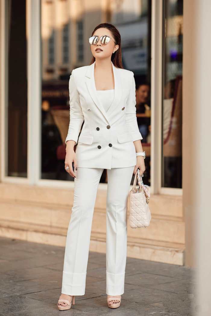 Màu sắc của cúc áo tạo điểm nhấn cho bộ suit nữ màu trắng trơn