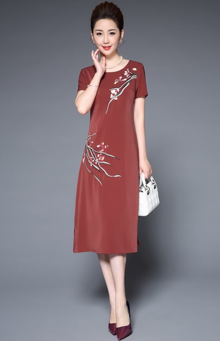 Váy liền thân dáng suông màu đỏ đất thể hiện sự trầm ấm của phụ nữ tuổi trung niên