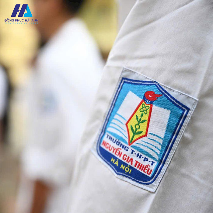 Logo của trường Nguyễn Gia Thiều được in ở phía bên tay trái của áo sơ mi trắng đồng phục